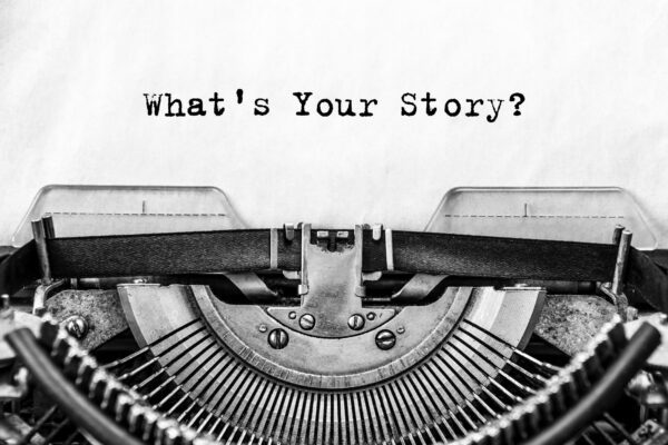 old fashioned typewriter with 'what's your story' written above